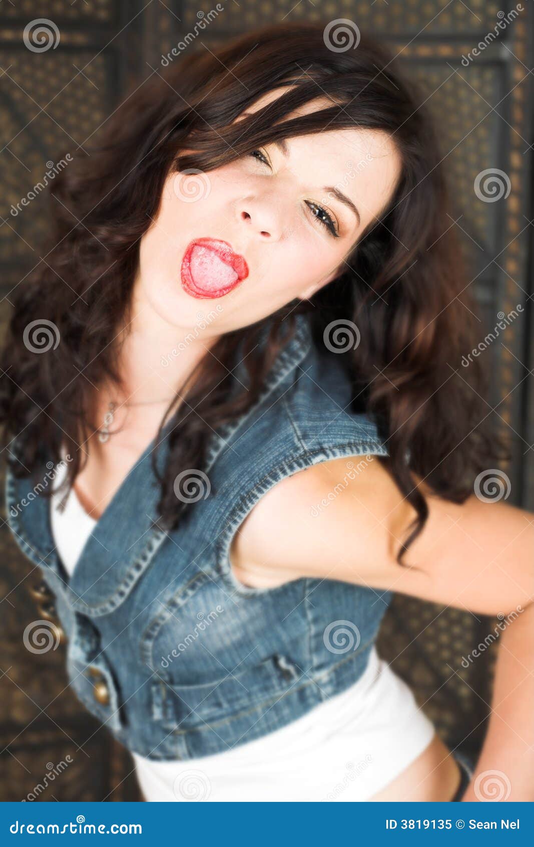 femme brune drôle avec un look attrayant, montre la langue, fait