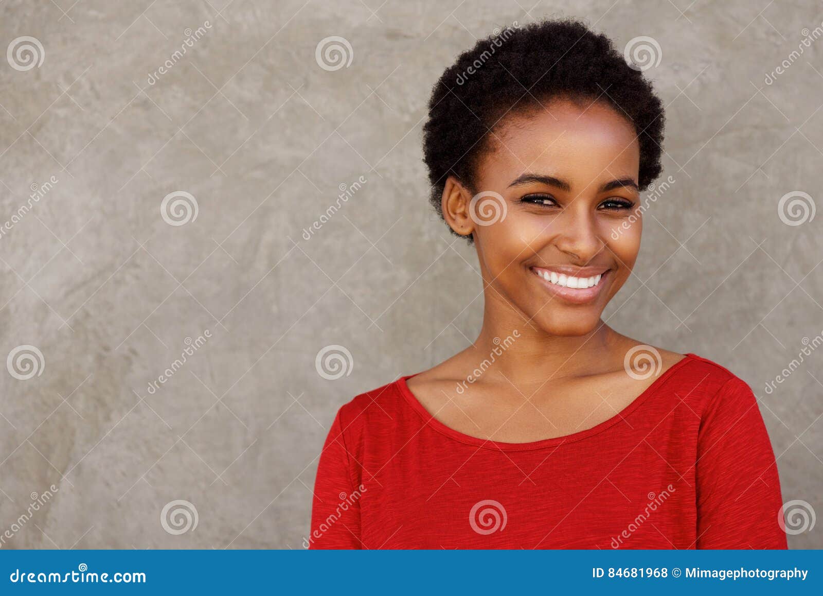 Jeune Femme De Couleur Attirante Dans Le Sourire Rouge De Chemise Photo