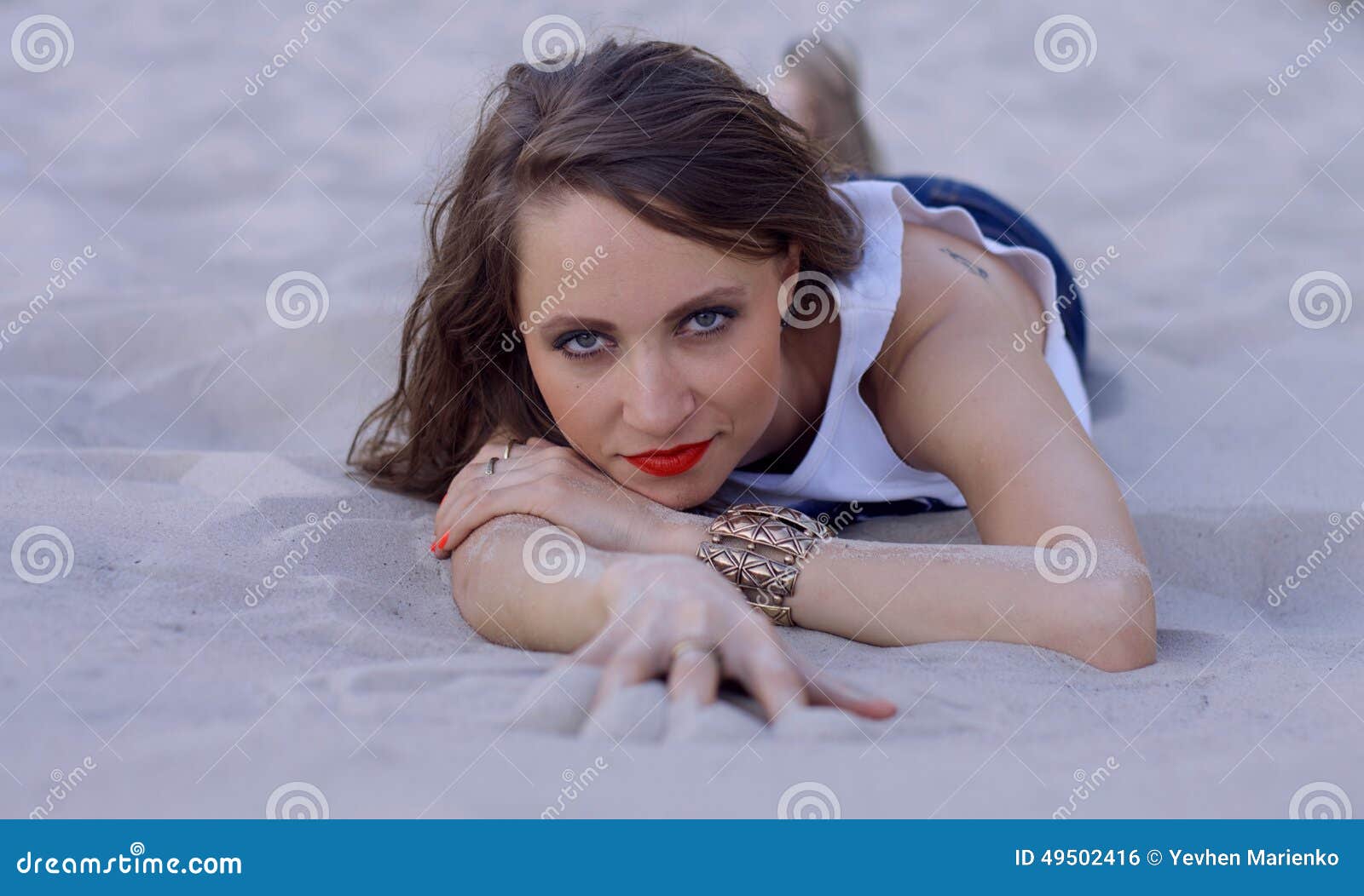 Jeune femme se trouvant sur le sable sur la plage, au sujet de quelqu'un ou de quelque chose rêver Sourire facile facial La durée est belle !