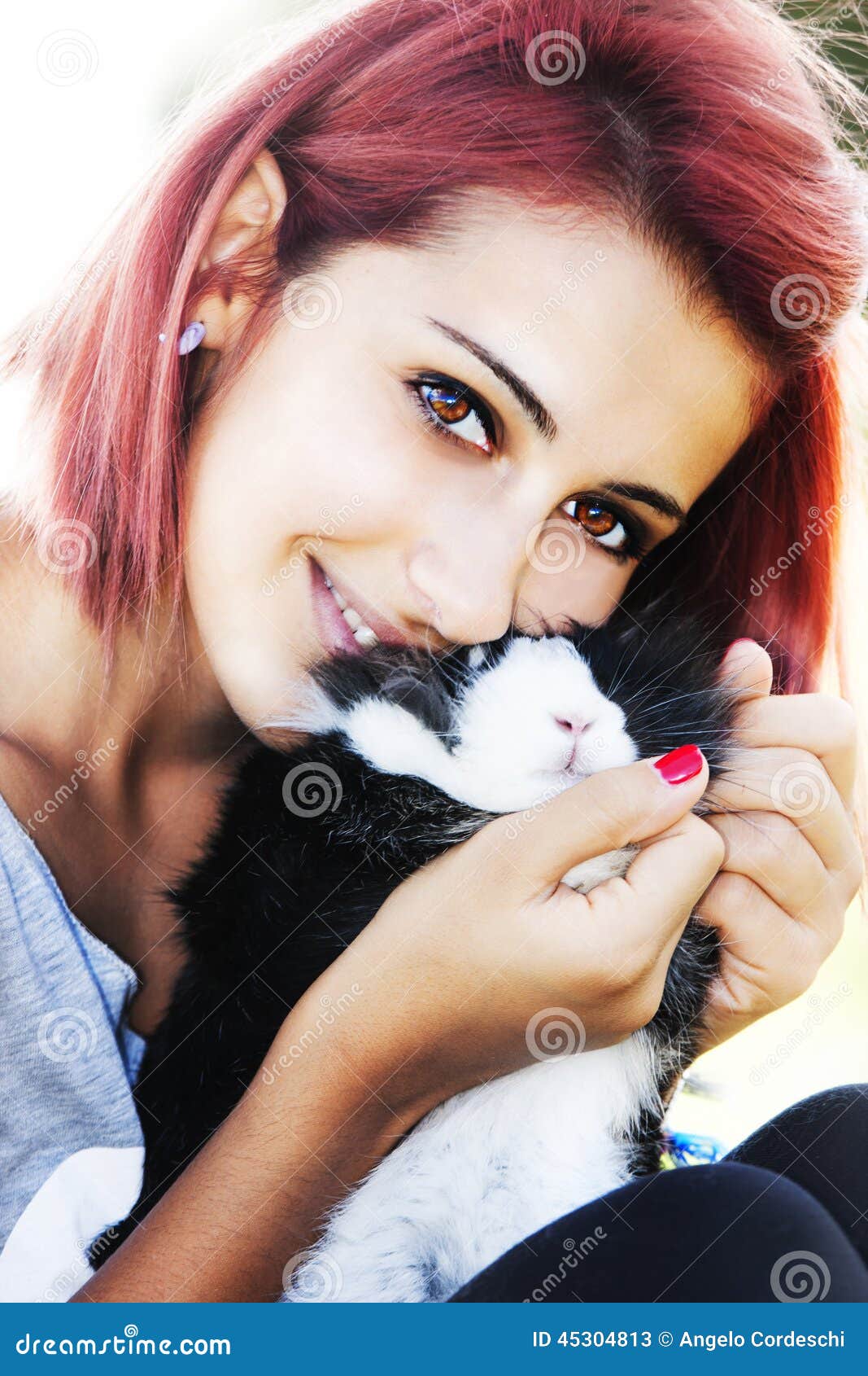 Jeune fille aimant son lapin Étreindre et embrasser. Une jeune fille rousse avec son lapin La fille est reposante et étreignante et embrassante le petit animal Le soleil intense derrière Lueur fascinante et effet de foyer doux