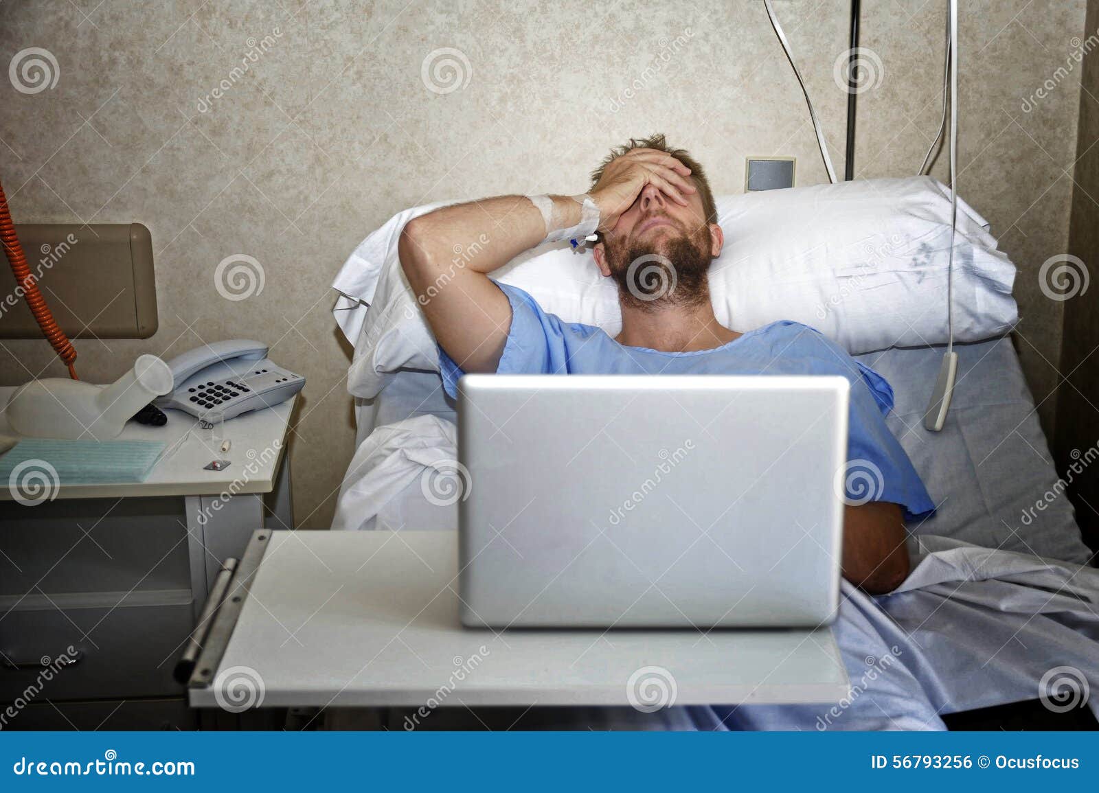 Jeune homme dans la chambre d'hôpital dans le lit utilisant l ...