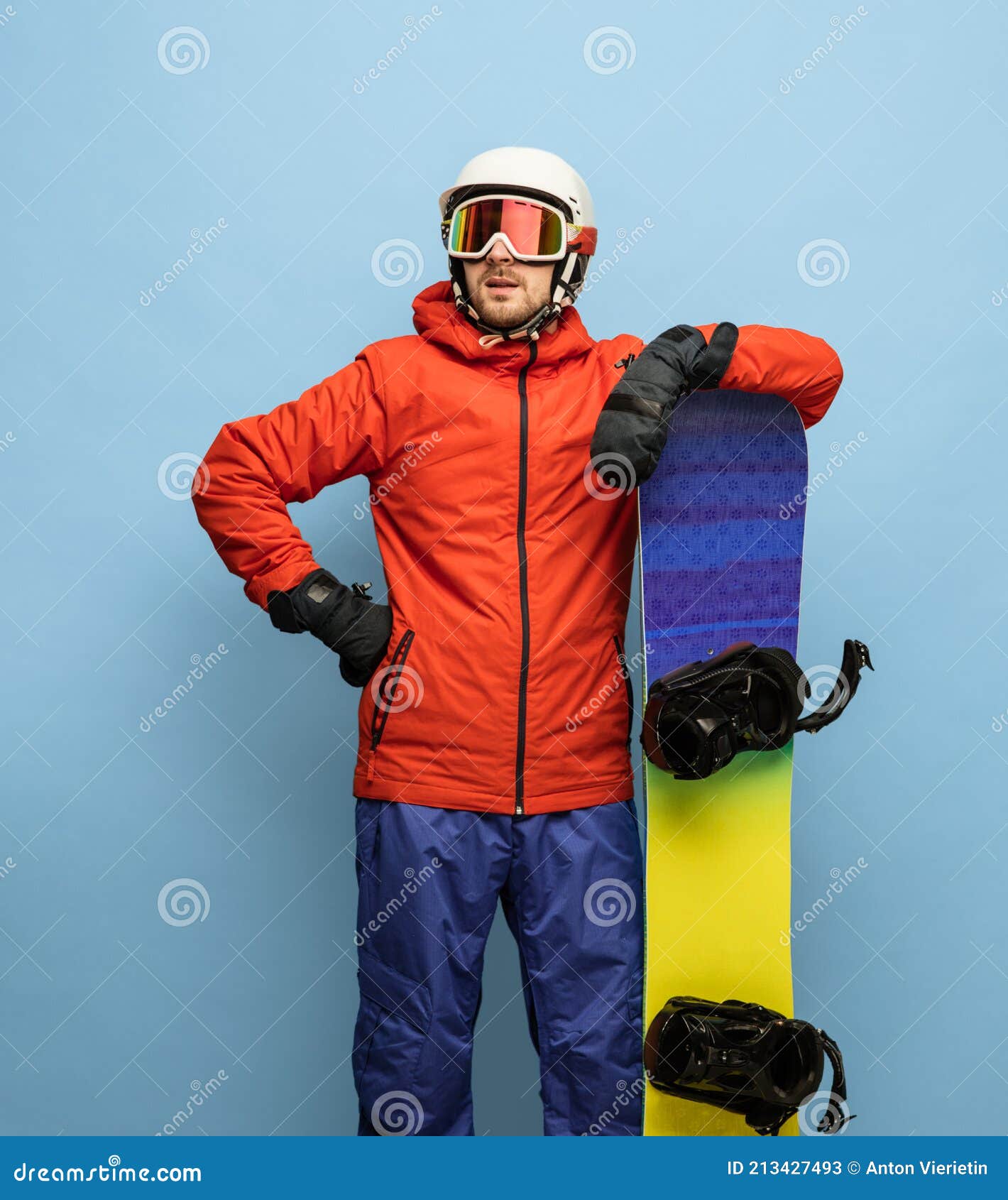 Jeune Homme En Combinaison De Ski Lumineuse Et Snowboard Isolé Sur Fond  Bleu. Image stock - Image du humeur, gens: 213427493