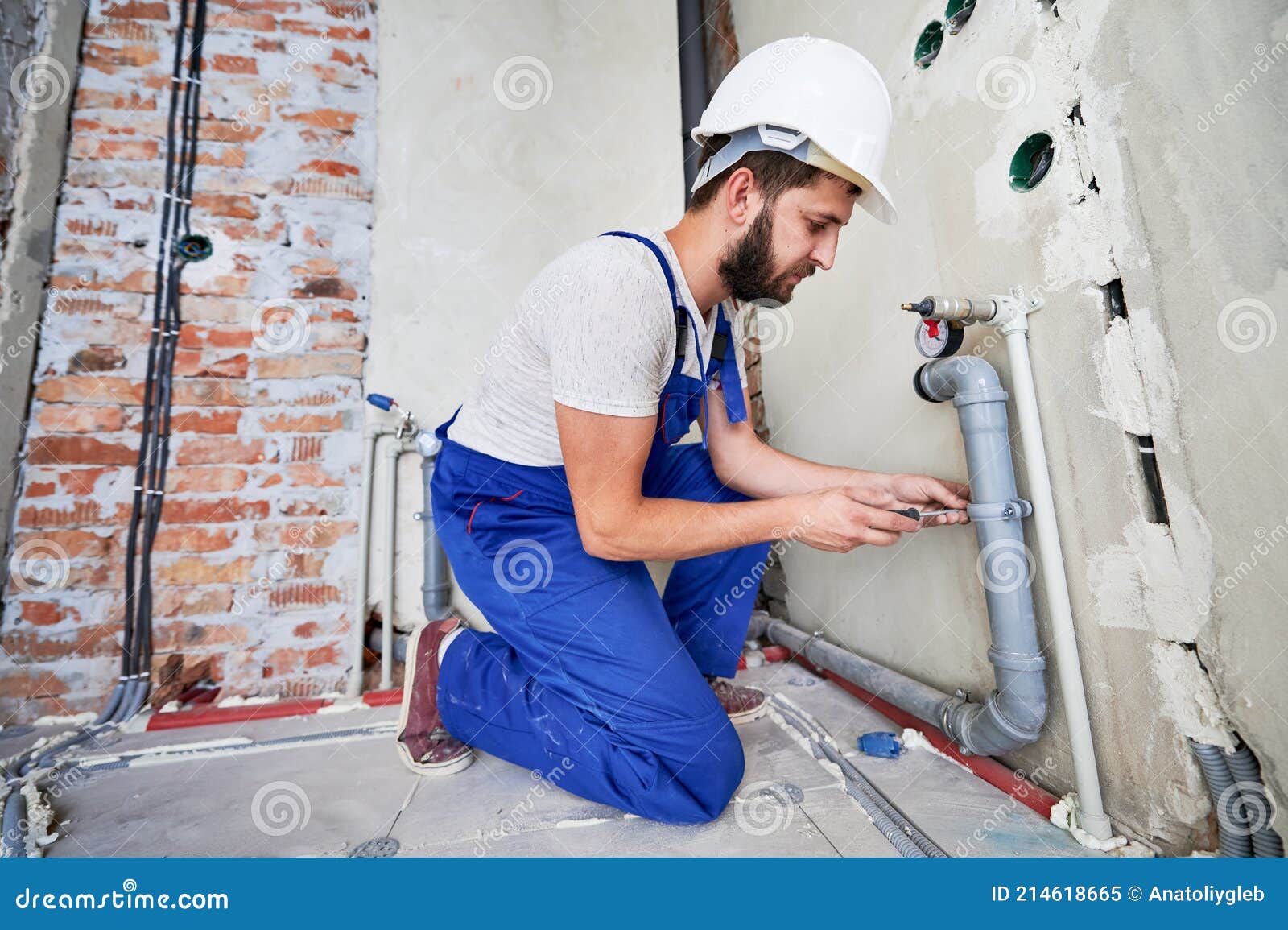 Jeune Plombier Travaillant Avec Des Tuyaux D'égout Gris Les Fixant Au Mur  Image stock - Image du bathroom, matériau: 214618665