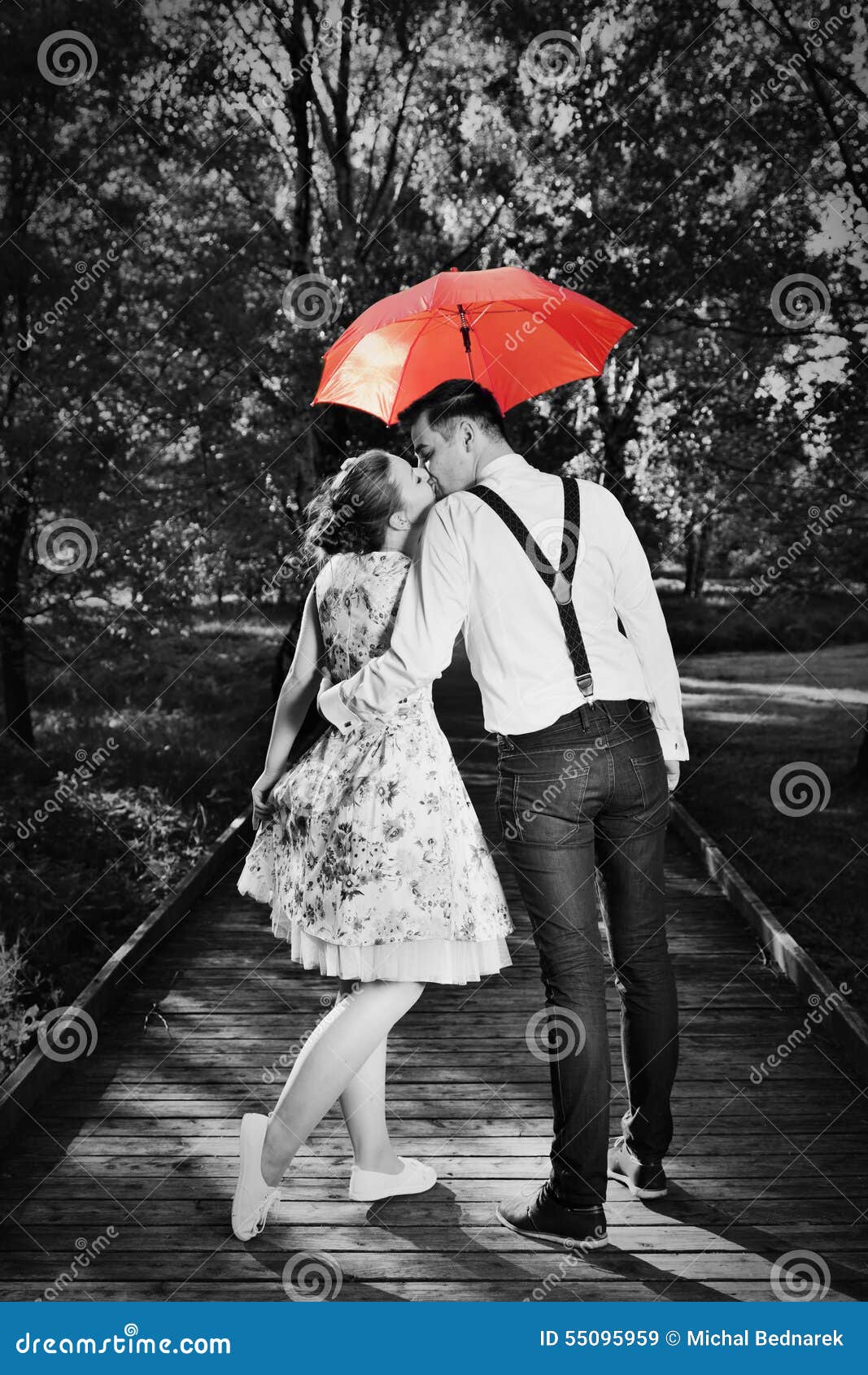 Portrait de couple s'embrassant plein de diamants, parapluie rouge