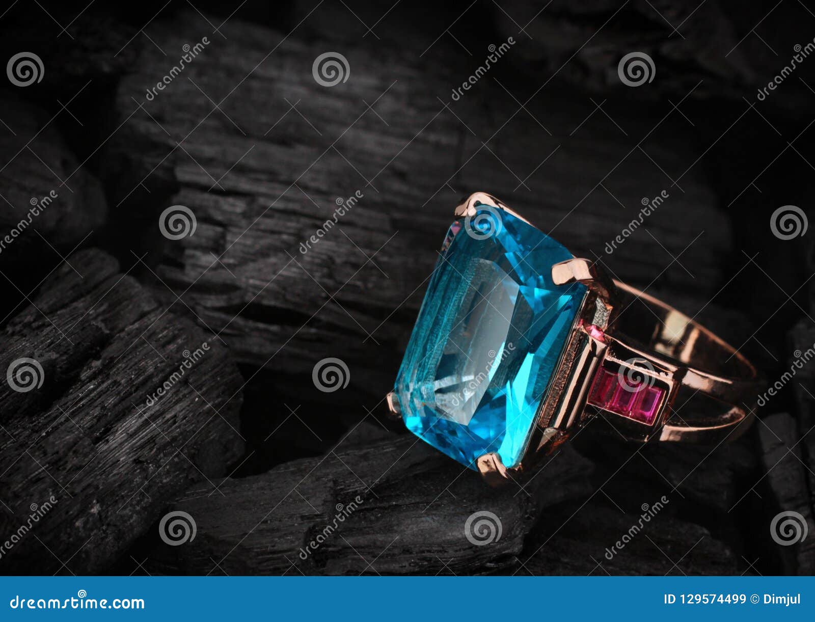 jewelery ring with aquamarine gemstone on dark coal background,