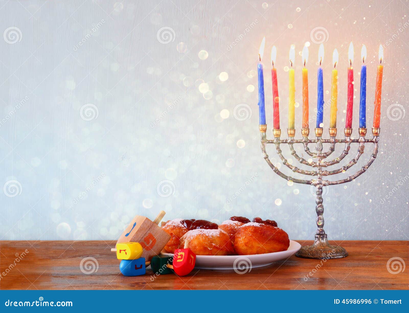 jewish holiday hanukkah with menorah, doughnuts over wooden table. retro filtered image