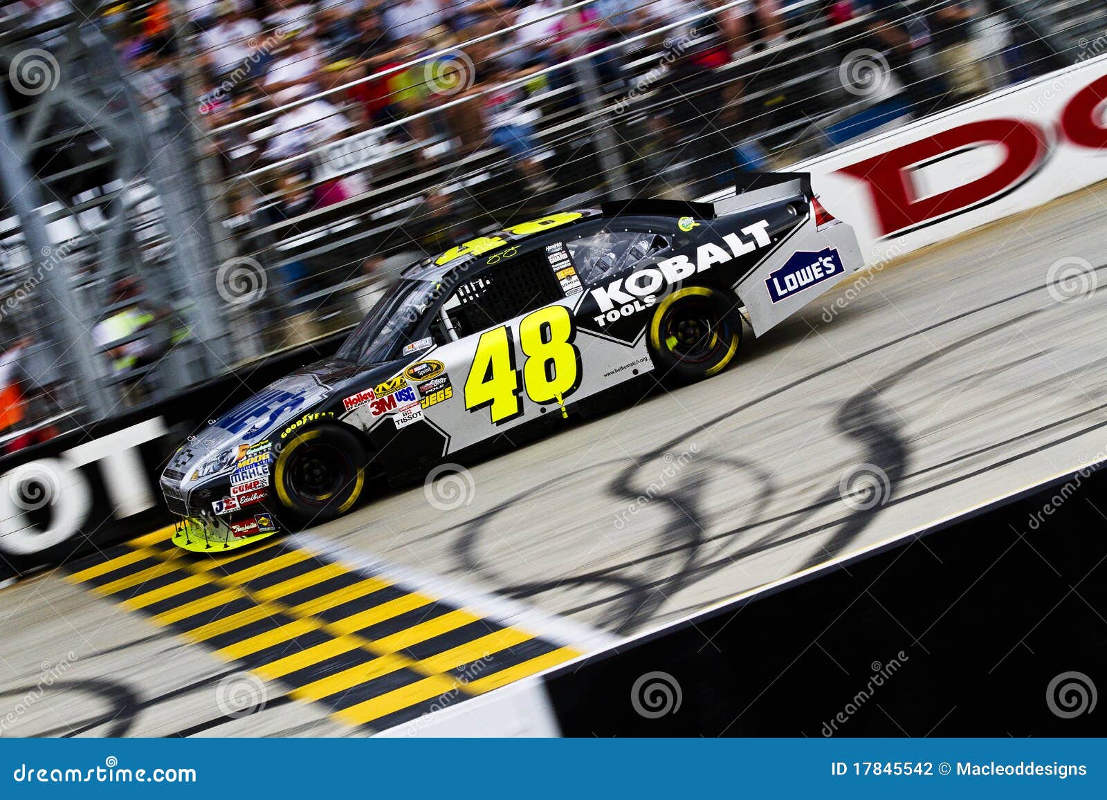 Jimmie Johnson Crosses Start Finish Line. DOVER, DE - SEP 26, 2010: Johnson crosses the finish line and takes the checkered flag winning the AAA 400 race at the Dover International Speedway in Dover, DE.