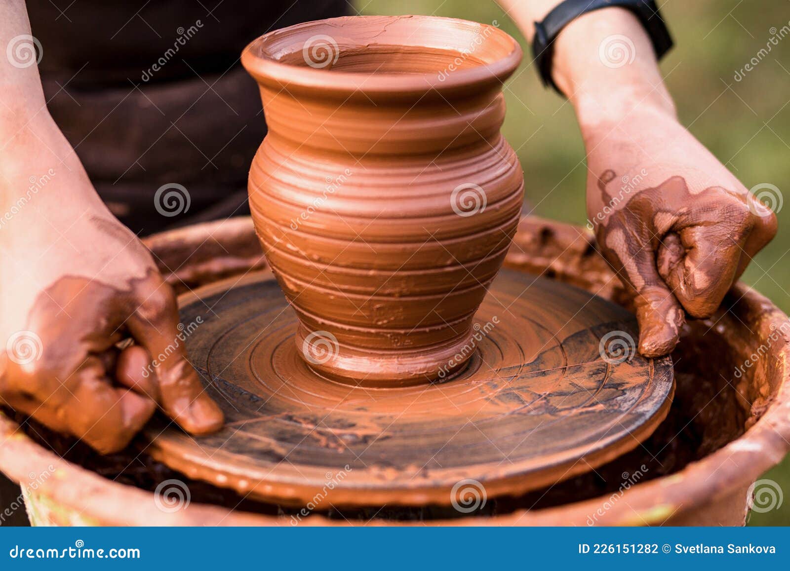 potter professional happy man working with brown clay in workshop . Stock  Photo by yurakrasil