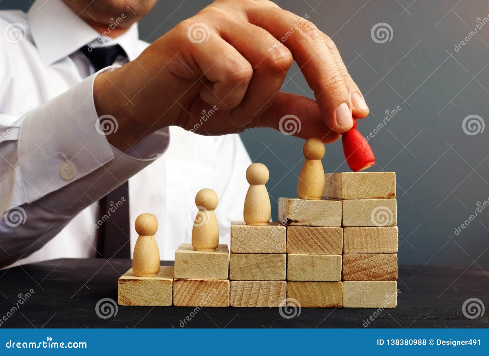job promotion. manager is holding figurine near career ladder.