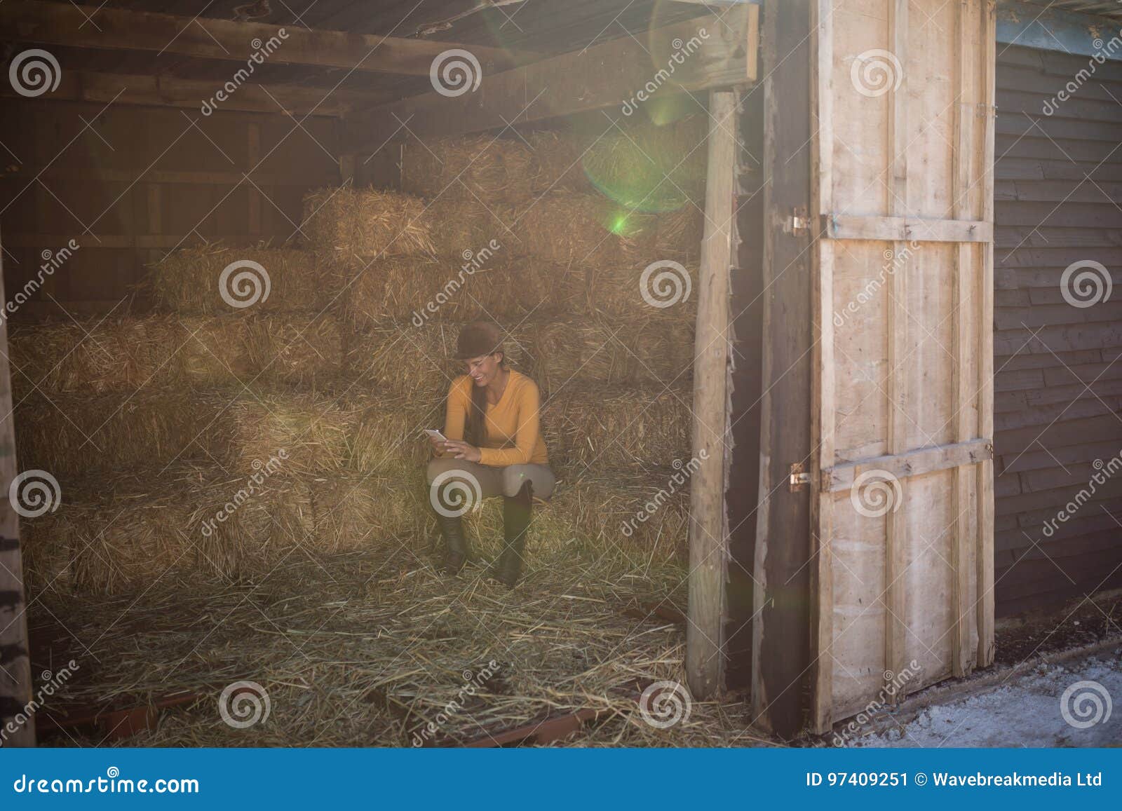 Jockey Using Phone in Stable Seen through Doorway Stock Image Image