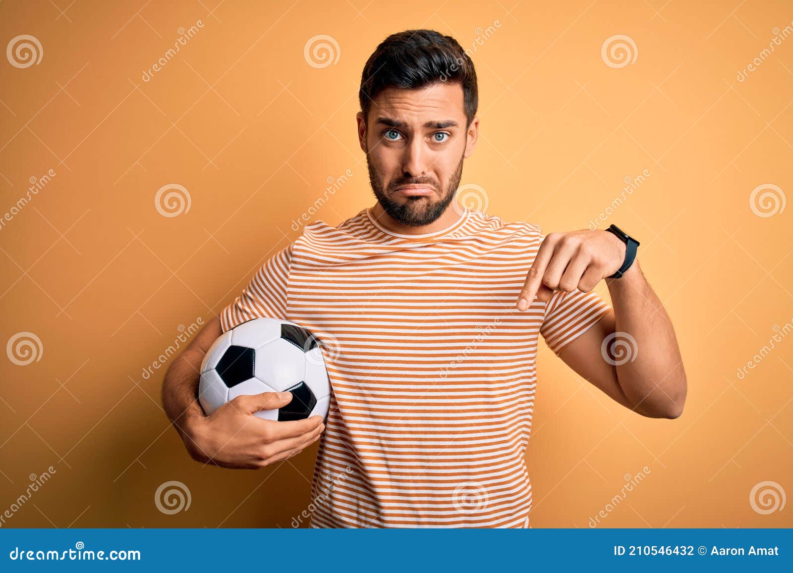 Jogador de futebol forte com bola de futebol e sorrindo em fundo branco  isolado