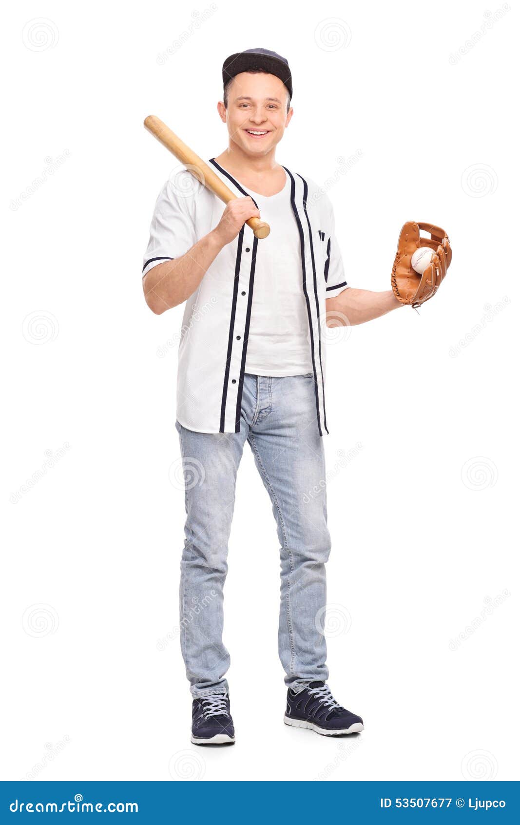 Jogador de beisebol masculino que guarda o bastão e uma bola. Retrato completo do comprimento de um jogador de beisebol masculino novo que mantém um bastão de beisebol e uma bola isolados no fundo branco