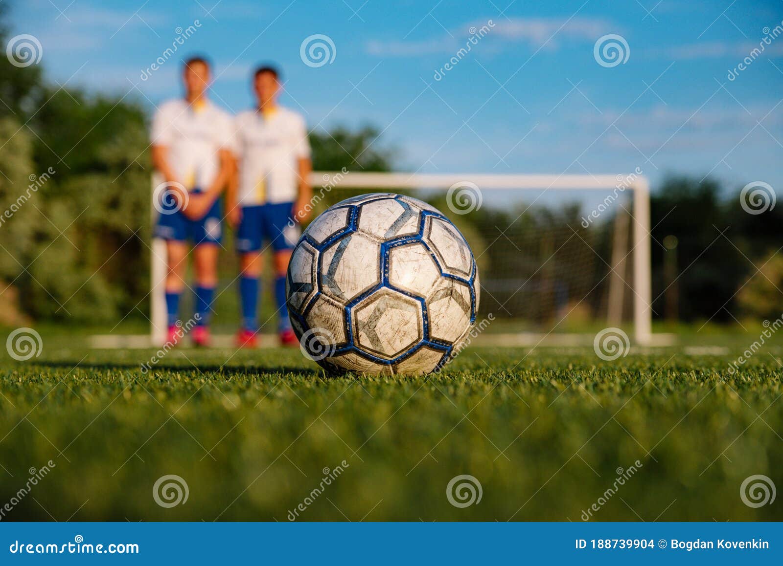 Um jogador de futebol chuta uma bola de futebol em um campo