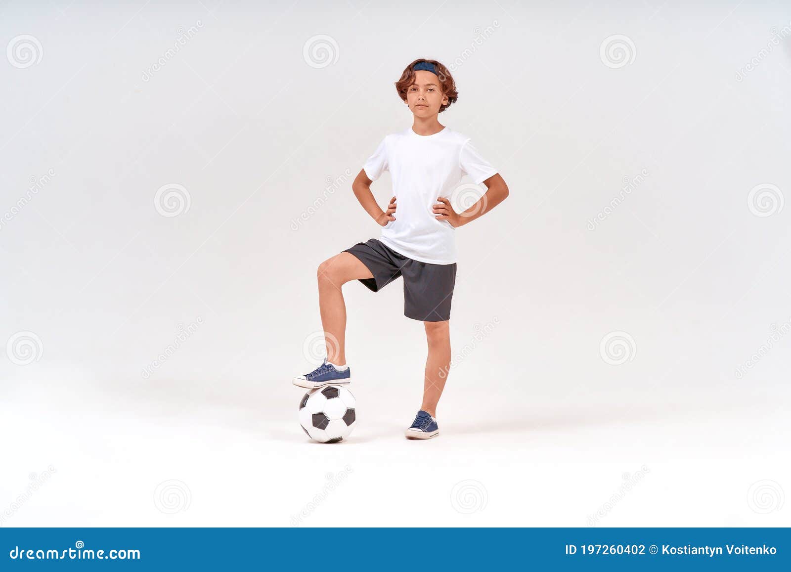 Jogador de futebol forte com bola de futebol e sorrindo em fundo branco  isolado