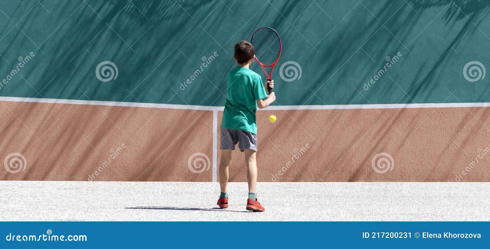 Jogador De Tênis Infantil Joga Tênis Sozinho Treinando Contra a