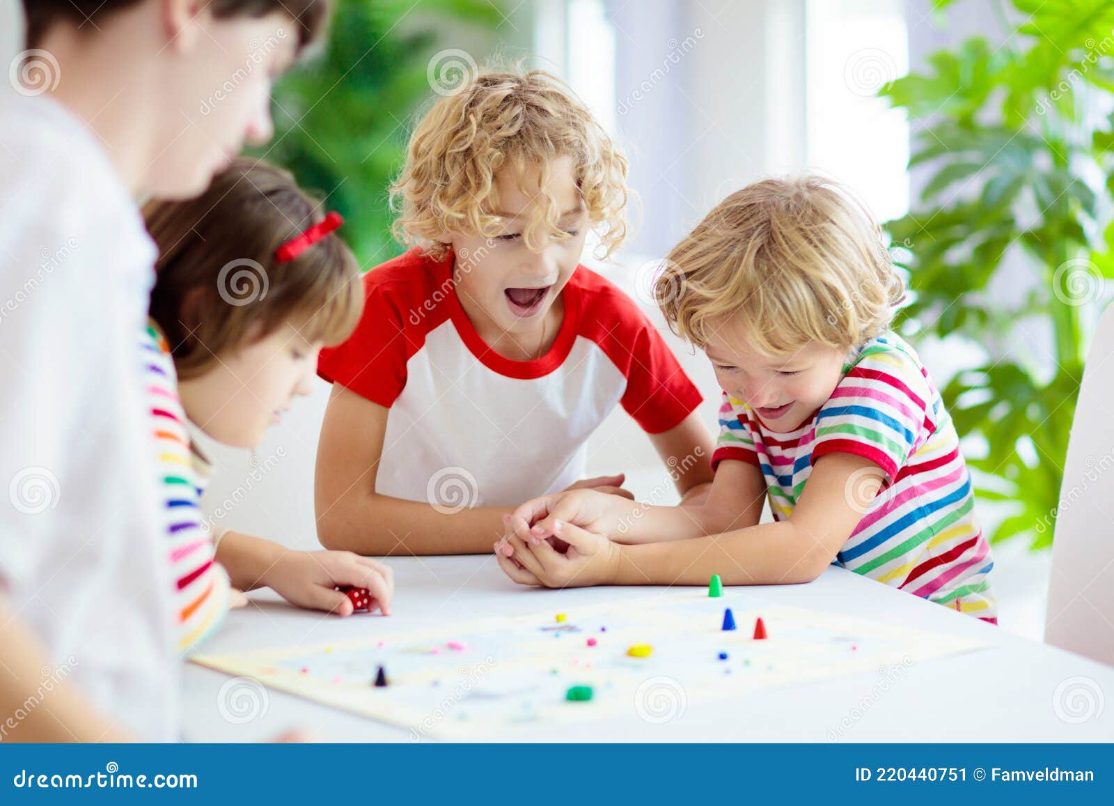 Brincadeiras dentro de casa. Criança jogando Ludo, um clássico dos