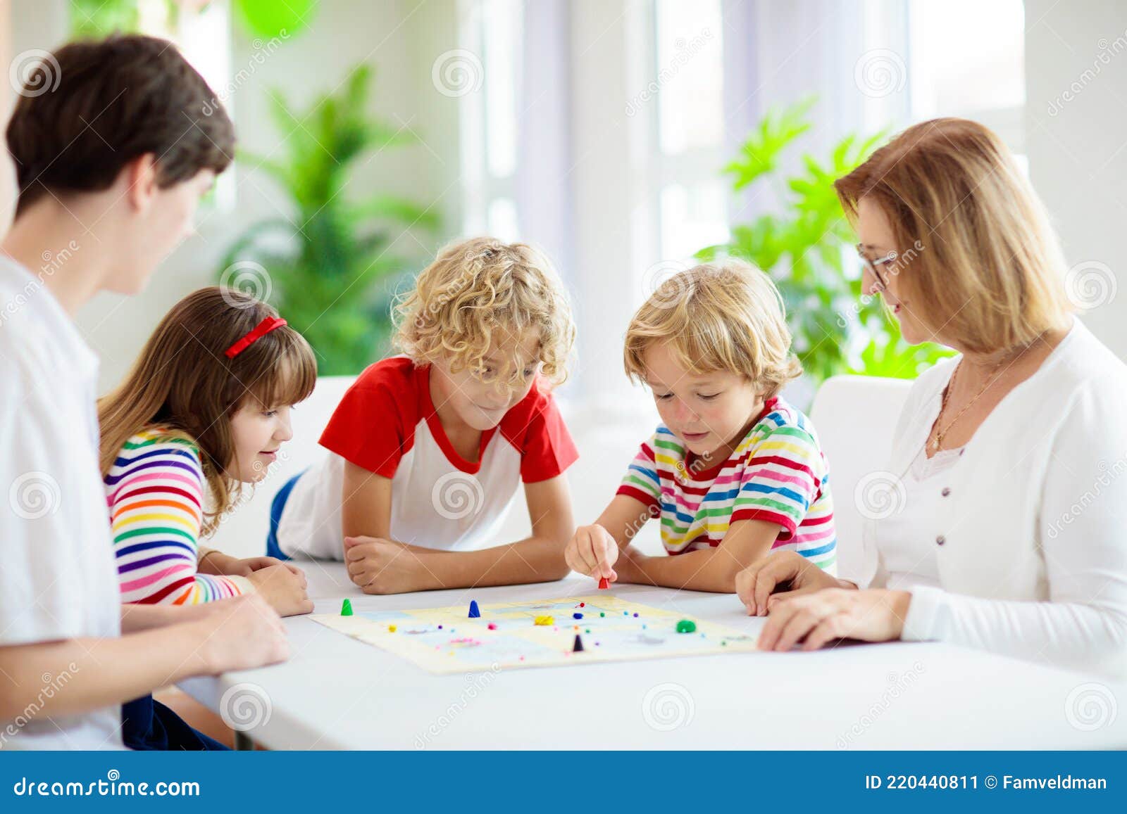 Brincadeiras dentro de casa. Criança jogando Ludo, um clássico dos