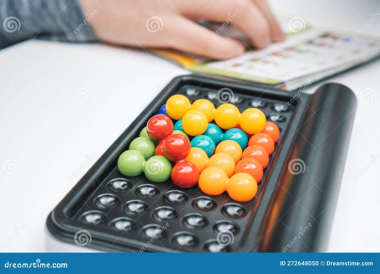 Jogo De Tabuleiro Fechado Com Campo Negro E Bolas Coloridas Em Buracos  Contra a Mão Desfocada Com Regras De Jogo. Resolver Quebra- Foto de Stock -  Imagem de brainteaser, serra: 272648050