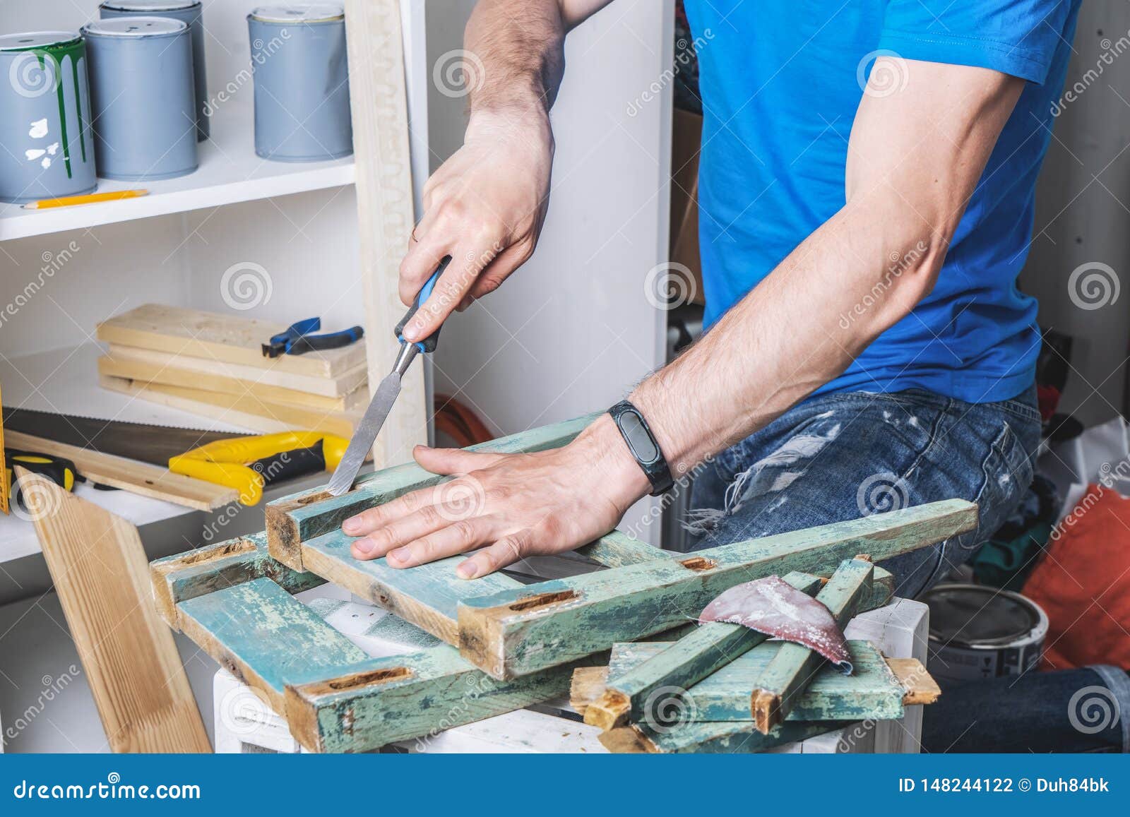 joinery: furniture master restores the old, dilapidated stool. closeup of a man`s hand.