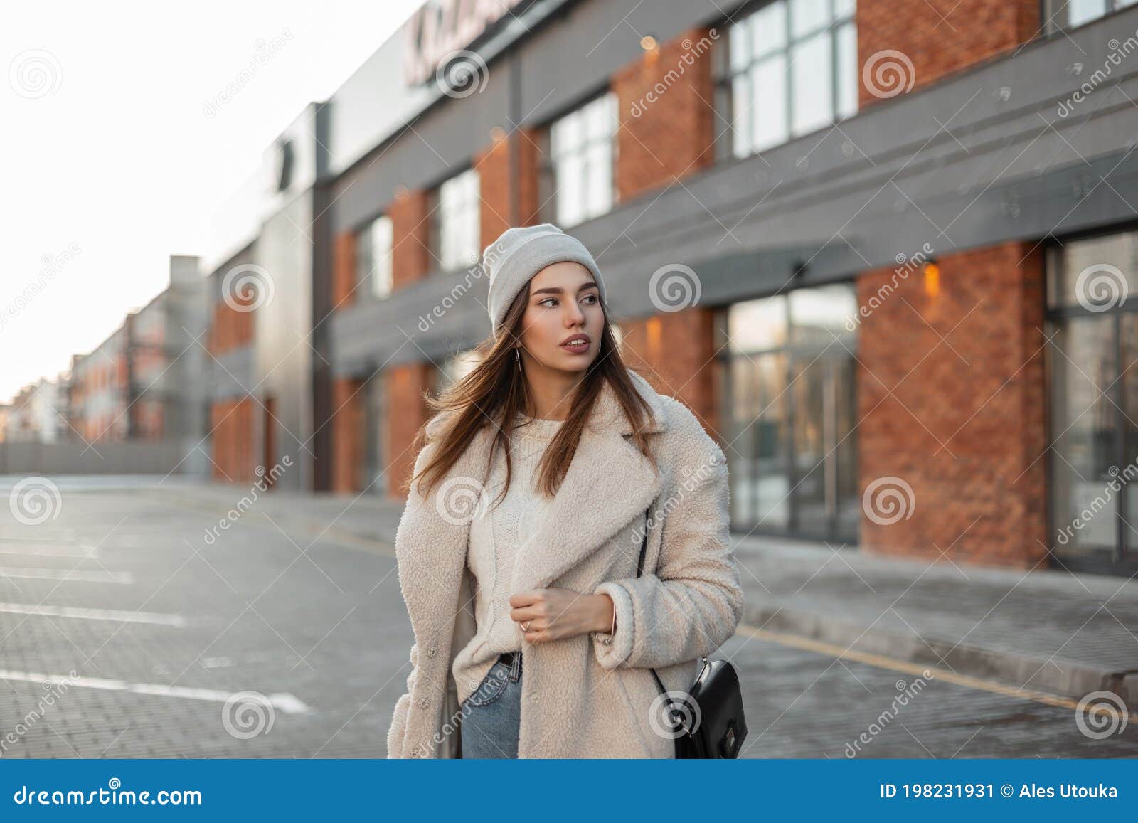 Mode Jolie Femme En Tenue D'hiver élégante Avec Bonnet Tricoté Avec Veste  Et Jean Bleu à L'extérieur. Style Décontracté Féminin