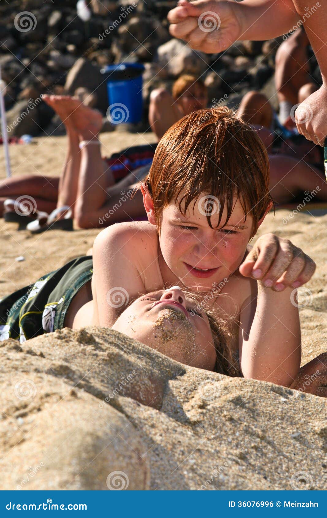 Jong meisje bij het strand met nat haar. Jongen en meisjes het spelen bij het strand die in het zand graven