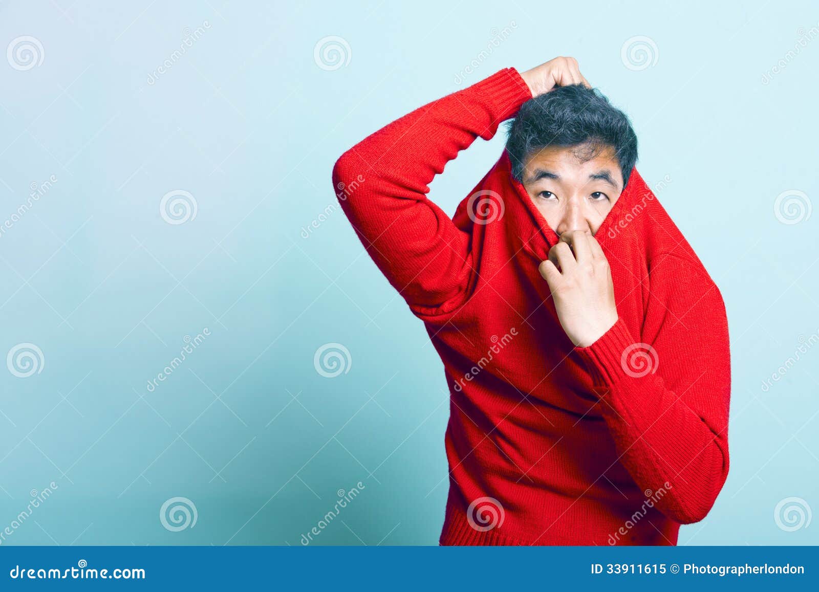Jonge Aziatische Mens die van Rode Sweater proberen te nemen