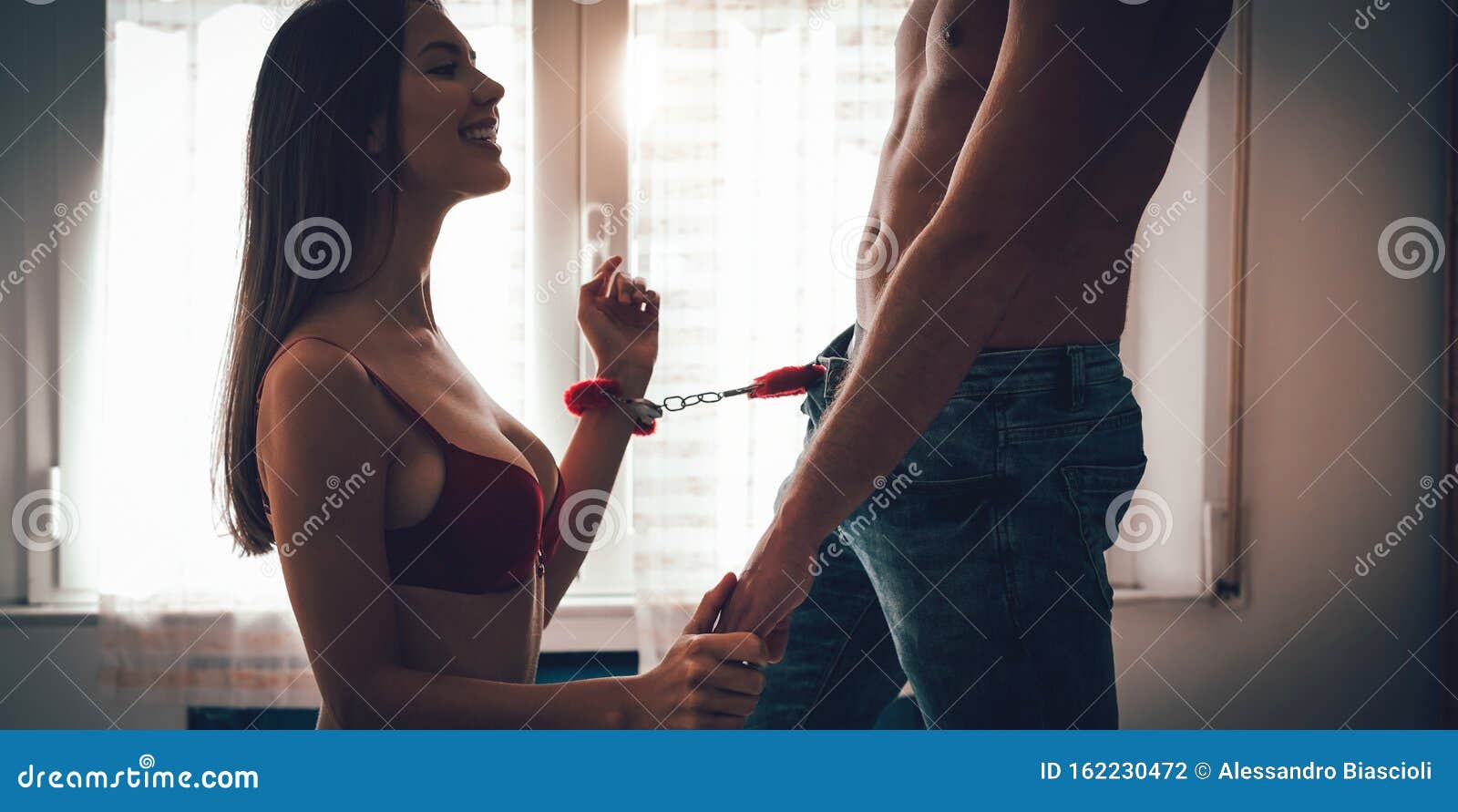 Jonge Echtparen Die Hete Seksoverheersing Spelen in Het Bed - Sensuele Vrouw Zat Vast Met Handboeien Terwijl Ze Haar Man Verleidd Stock Foto foto