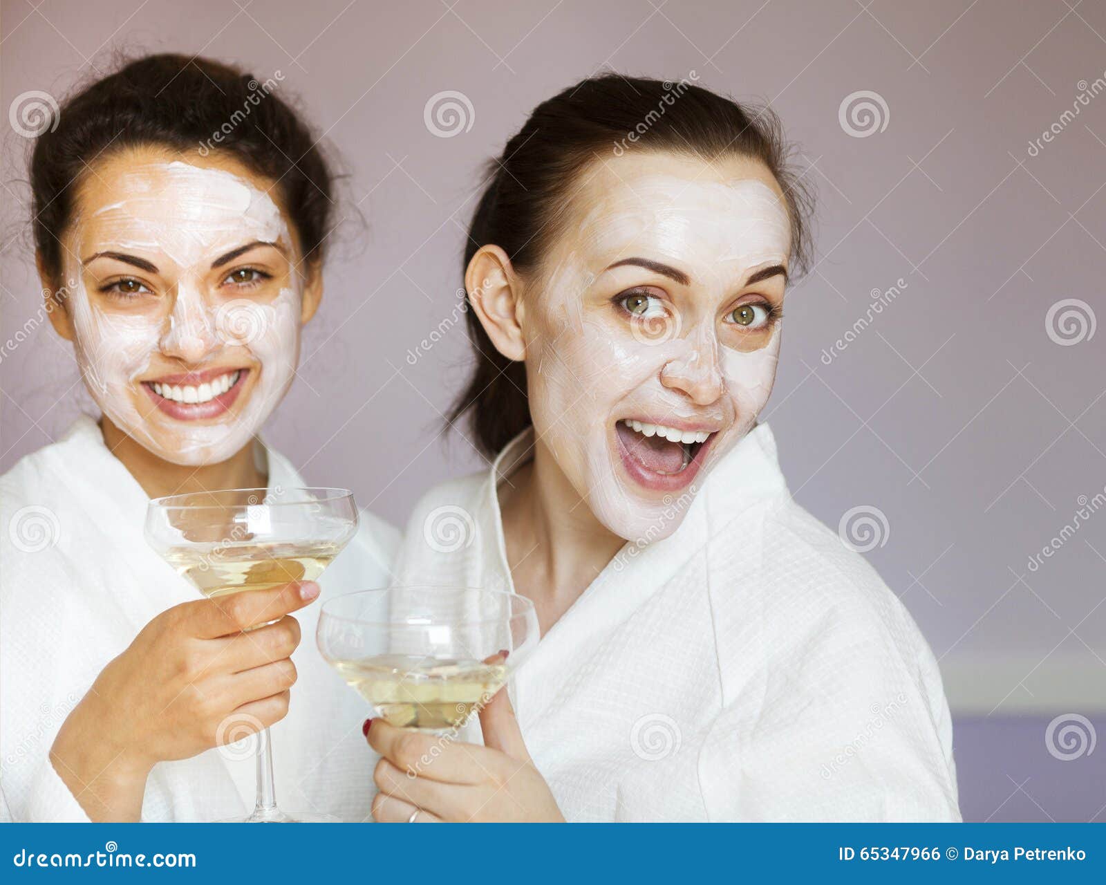 De jonge gelukkige vrouwelijke vrienden die champagne in kuuroord drinken en hebben pret