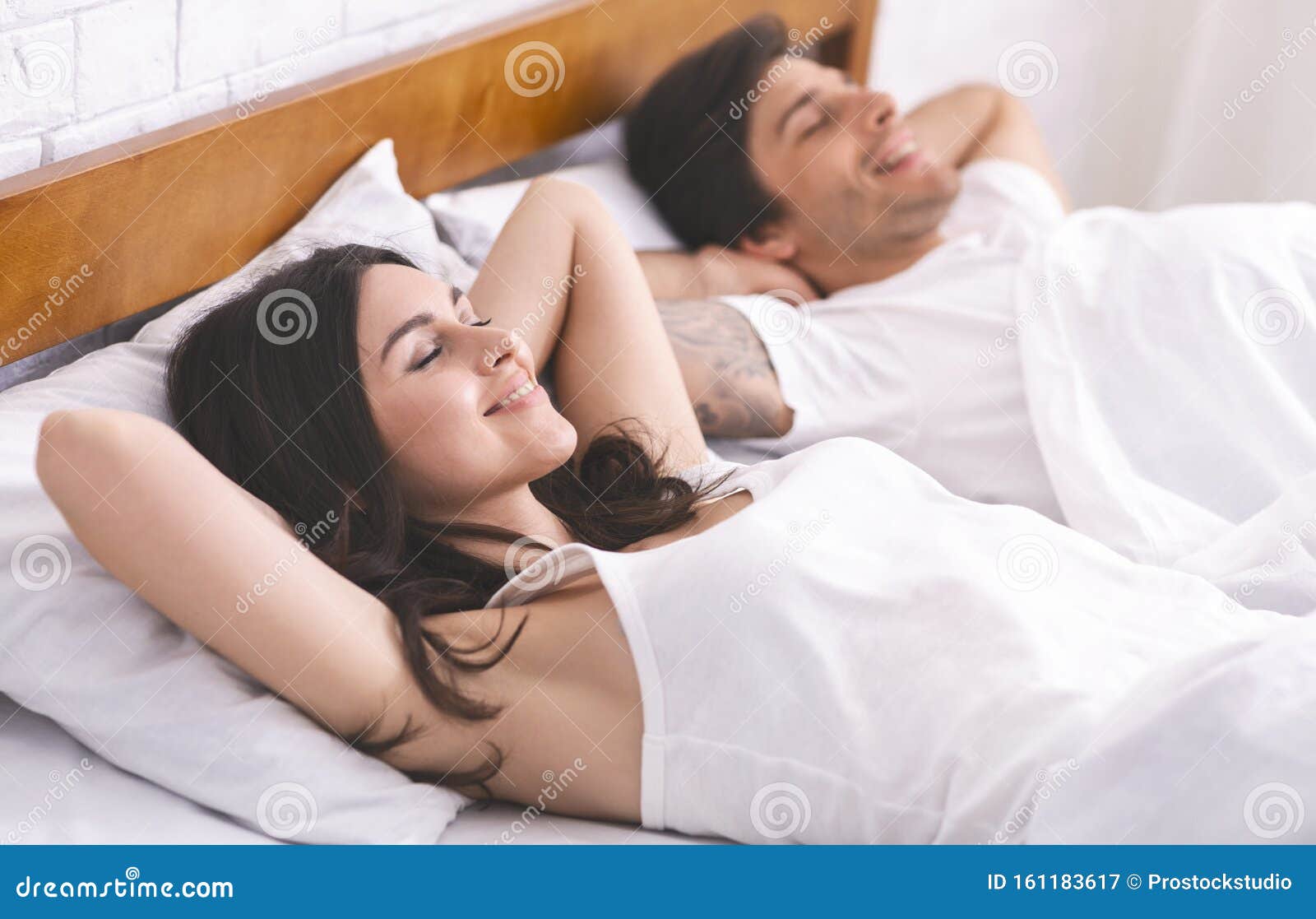 Jonge Tevreden Man En Vrouw Die in Bed Ontspannen Zijn Stock Afbeelding