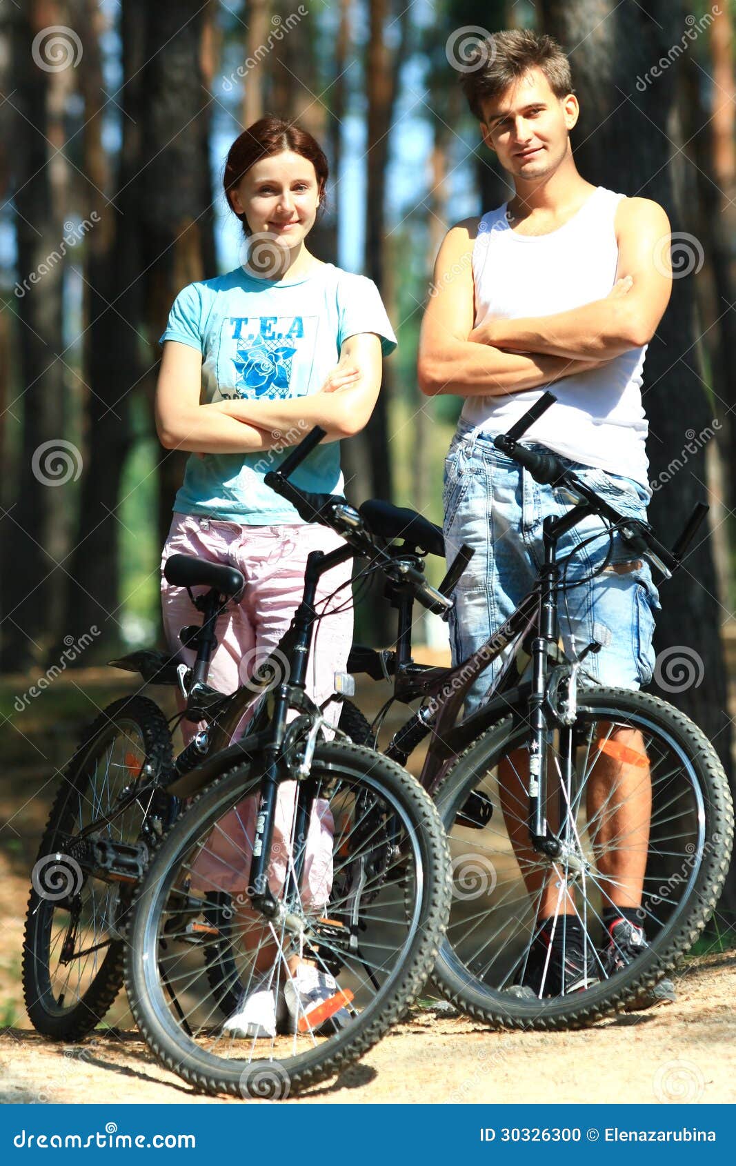 Jonge vrouw en man met fietsen. Jonge witte vrouwen en mannen met fietsen in het bos