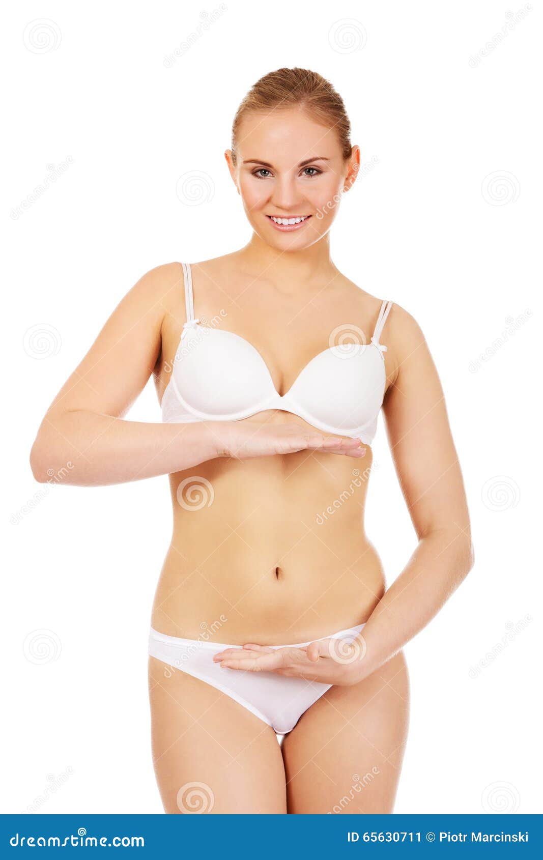 Jonge vrouw in witte lingerie met hand op buik