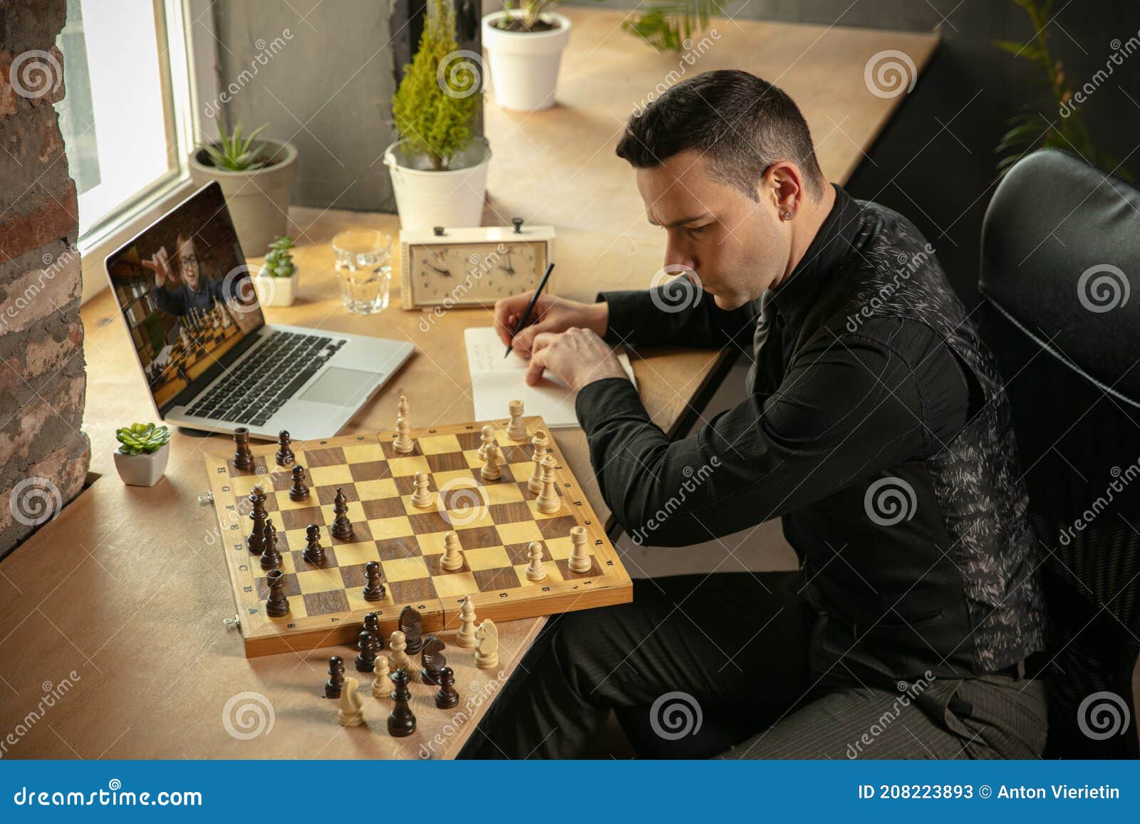 Menino ruivo de óculos sentado em casa e a jogar xadrez sozinho