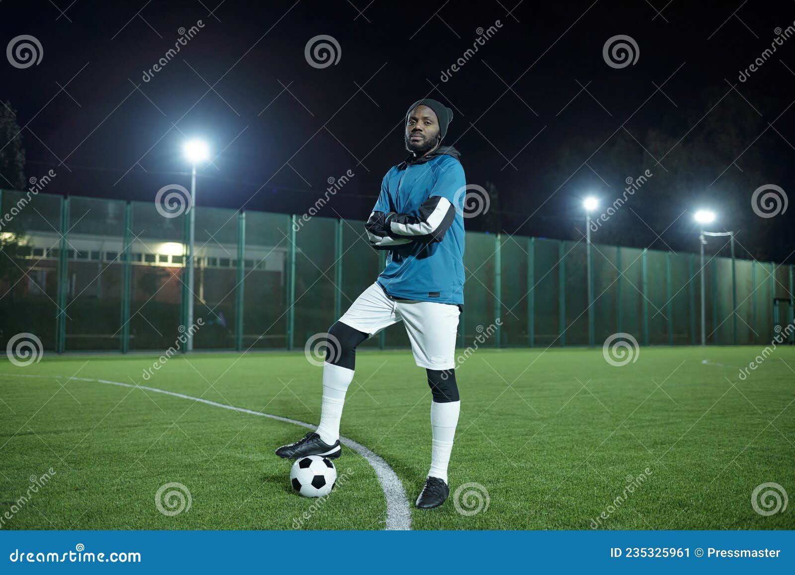 Seção baixa do jogador de futebol profissional que vai chutar a bola de  futebol de pé em um grande campo durante o jogo