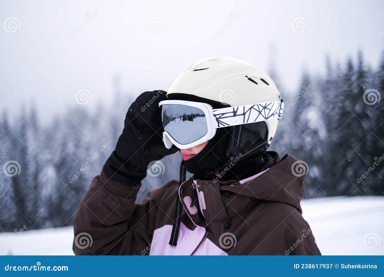 Hombre sonriente feliz en gafas de sol posando en la nieve al aire libre