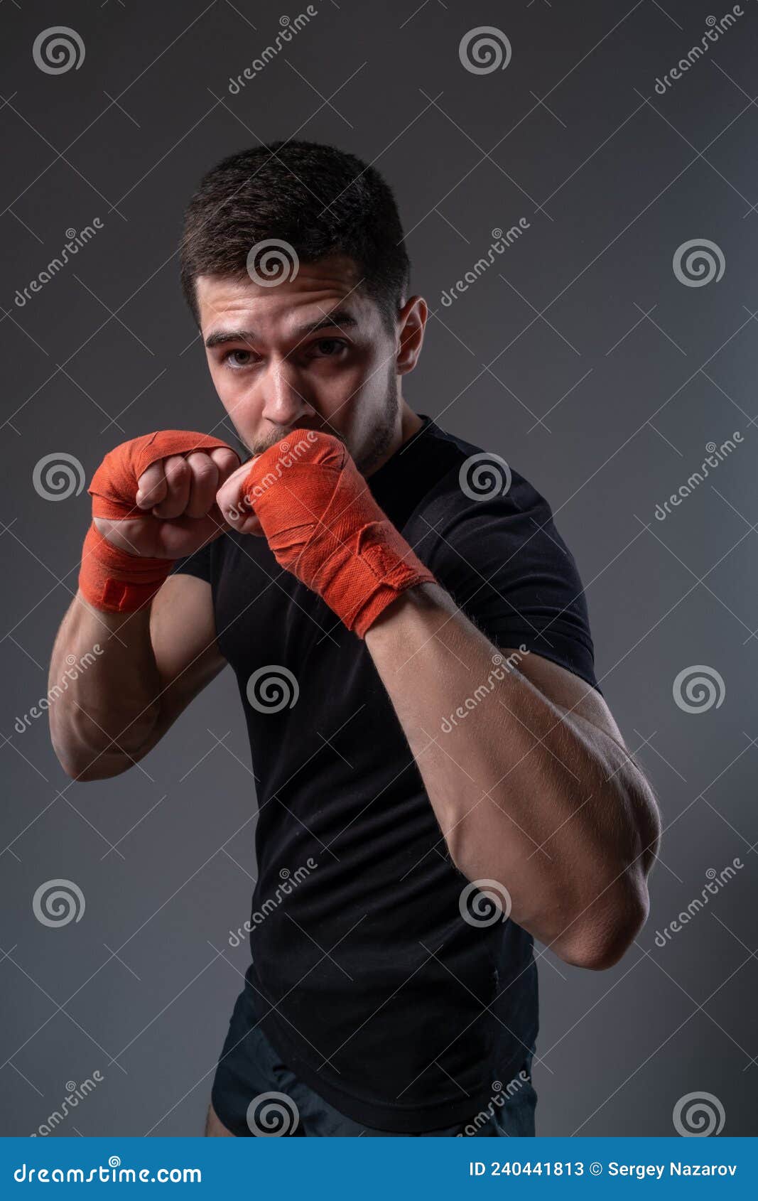 Recorta La Imagen De Un Joven Deportista En Posición De Boxeo Que Ha  Vendado Las Manos Con Vendas Rojas. La Mujer Parece Enojada. La Cara Está  En Foco. La Mano Es Borrosa.