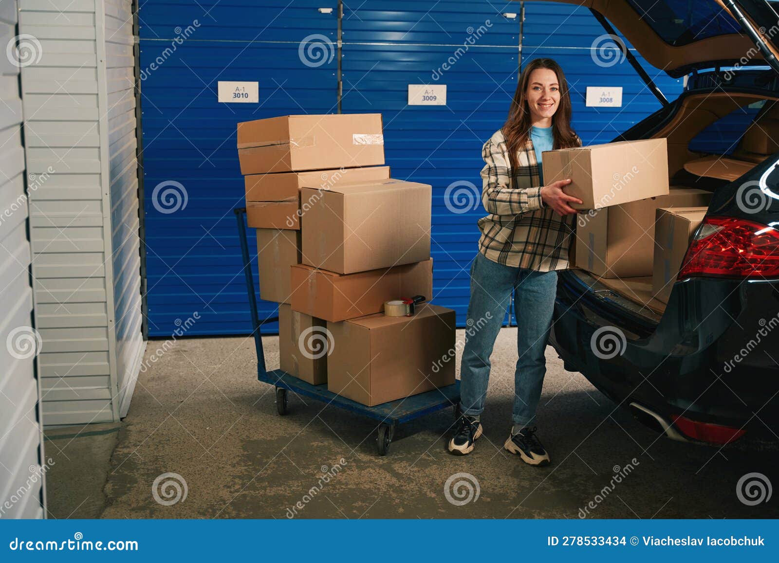 Coche con cajas de cartón en el maletero en un almacén con unidad