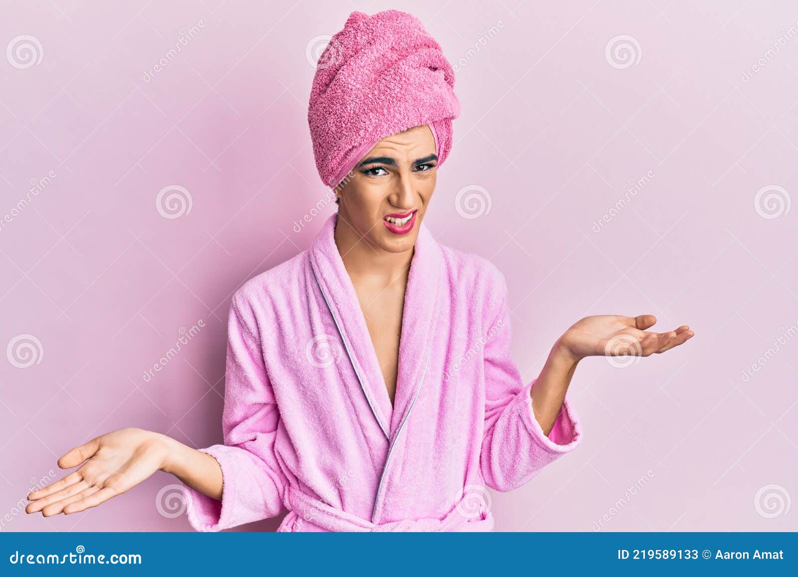 https://thumbs.dreamstime.com/z/joven-hombre-que-usa-mujer-maquillaje-usando-toalla-de-ducha-en-la-cabeza-y-albornoz-despistado-confundido-con-los-brazos-abiertos-219589133.jpg