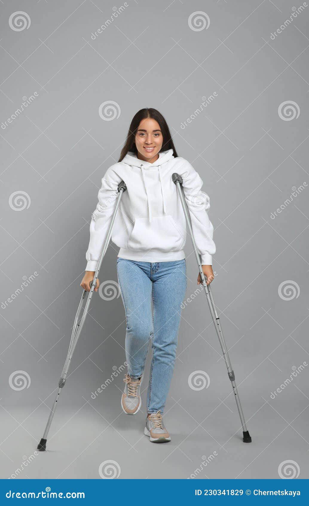 Joven Mujer Con Muletas Axilares En Fondo Gris Imagen de archivo - Imagen  de paciente, salud: 230341829