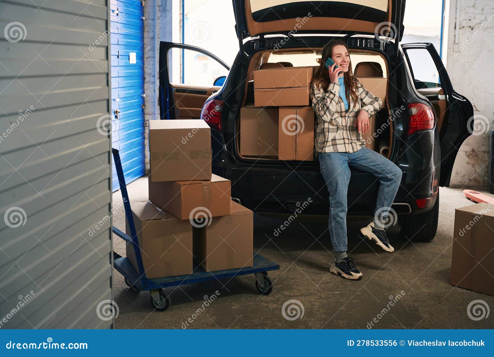 Joven Mujer Con Teléfono Móvil Y Cajas De Cartón Cerca Del Maletero Del  Coche Al Almacén Foto de archivo - Imagen de concepto, coche: 278533556