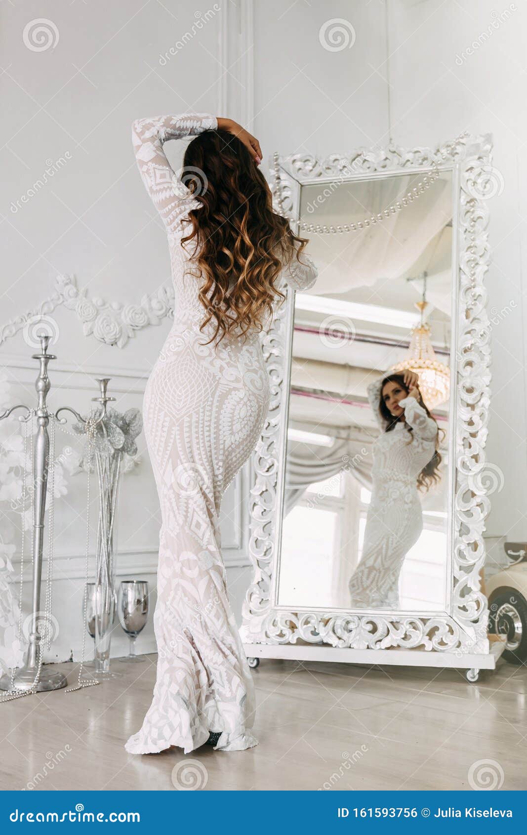 Elegante mujer joven delgada en vestido blanco