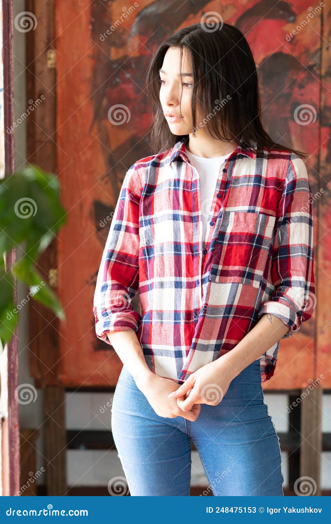 Joven Mujer Posa Con Camisa Roja Jeans Azules En El Estudio Imagen de archivo - Imagen de elegante,
