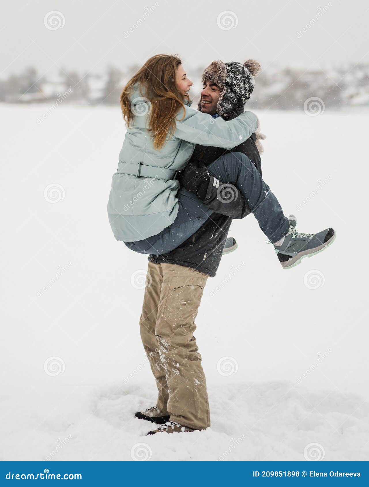 Joven Pareja Feliz Caminando En Invierno. Hombre Levantando a Su Mujer Foto  de archivo - Imagen de invierno, nieve: 209851898