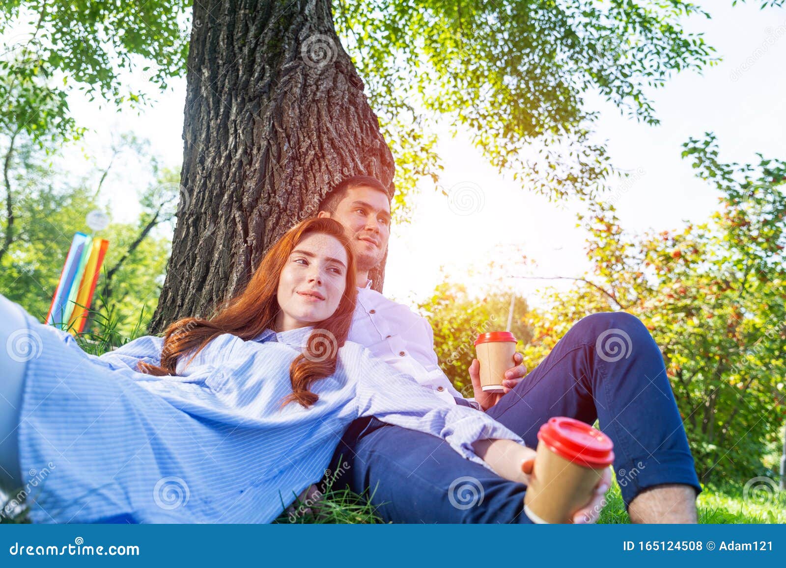 Joven Pareja Relajándose Con El Café Bajo El árbol Foto de archivo - Imagen  de bebida, romance: 165124508