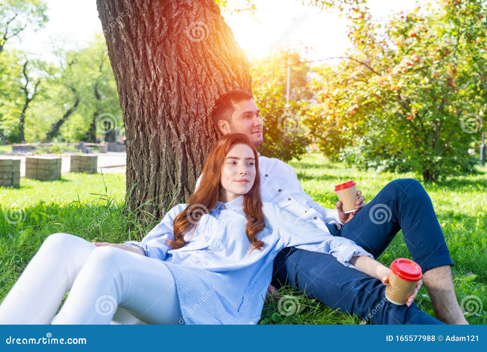 Joven Pareja Relajarse Con Un Café Bajo Un árbol Foto de archivo - Imagen  de amistad, bosque: 165577988