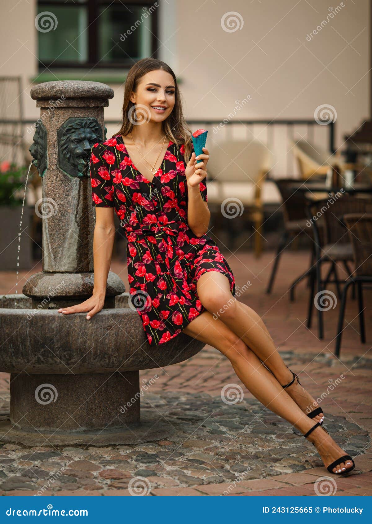 Joven Y Alegre Mujer Con Cabello Ondulado Vestido Con Flores Rojas Comiendo Delicioso Helado Cerca De La Fuente Imagen de archivo - Imagen de gente, encanto: 243125665