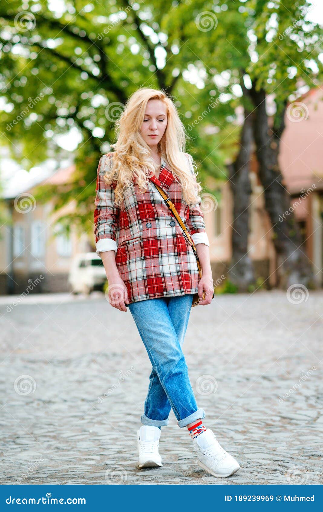 Retrato de moda de una mujer joven con ropa elegante en la calle