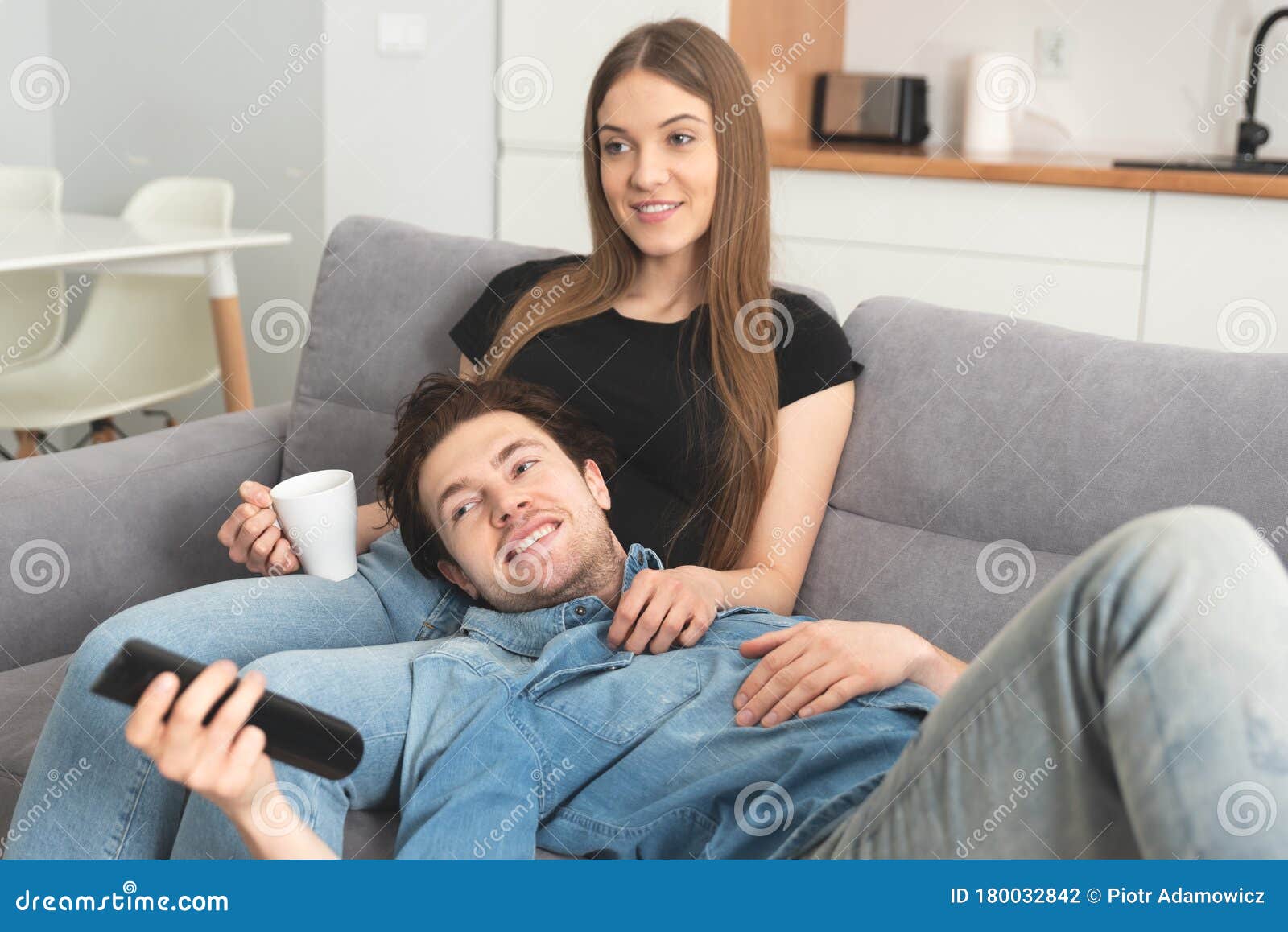 Foto de Dois Amigos Sorridentes No Sofá Assistindo Tv Juntos No Escuro e  mais fotos de stock de Assistir TV - iStock