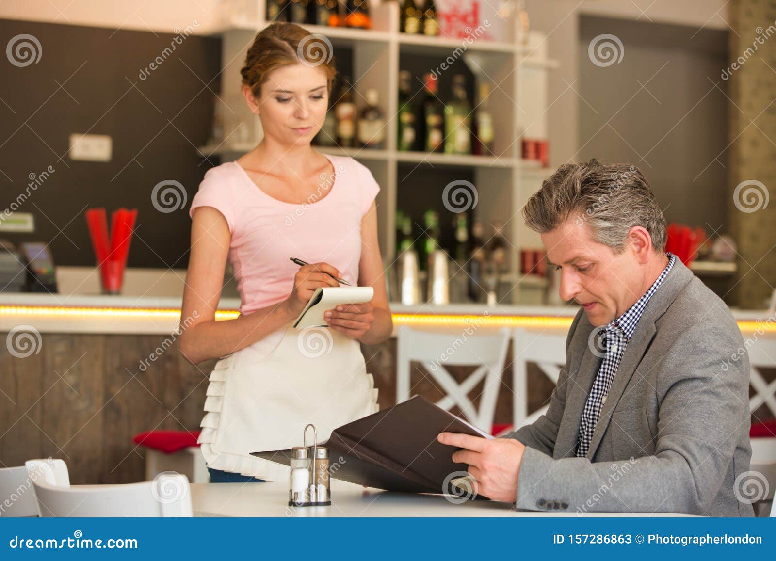 Garçonete recebendo ordens de pessoas no restaurante