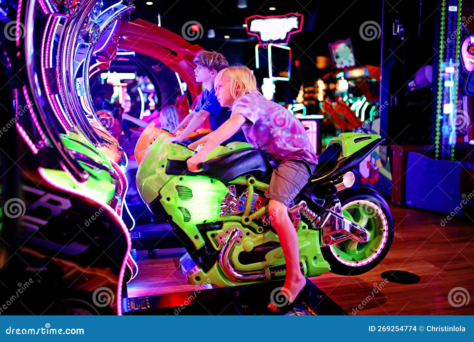 Jovens Jogando Um Jogo De Motocicleta No Fliperama De Luzes Neon Foto de  Stock - Imagem de preto, luzes: 269254774