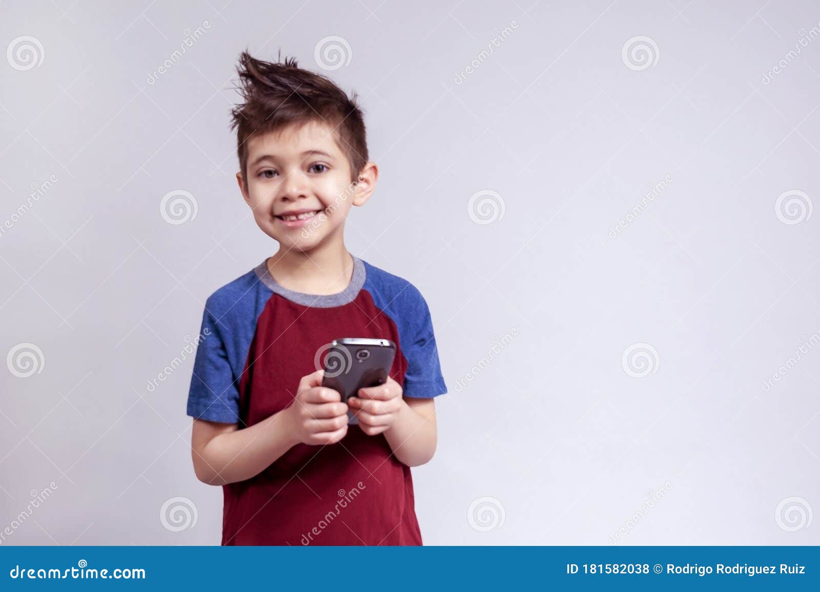 Enfant Tenant Un Téléphone Portable Sur Fond Blanc